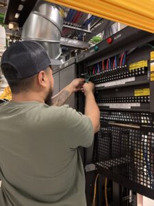 An electrician from Mario Electric connecting wires in an electrical panel in San Antonio, TX.