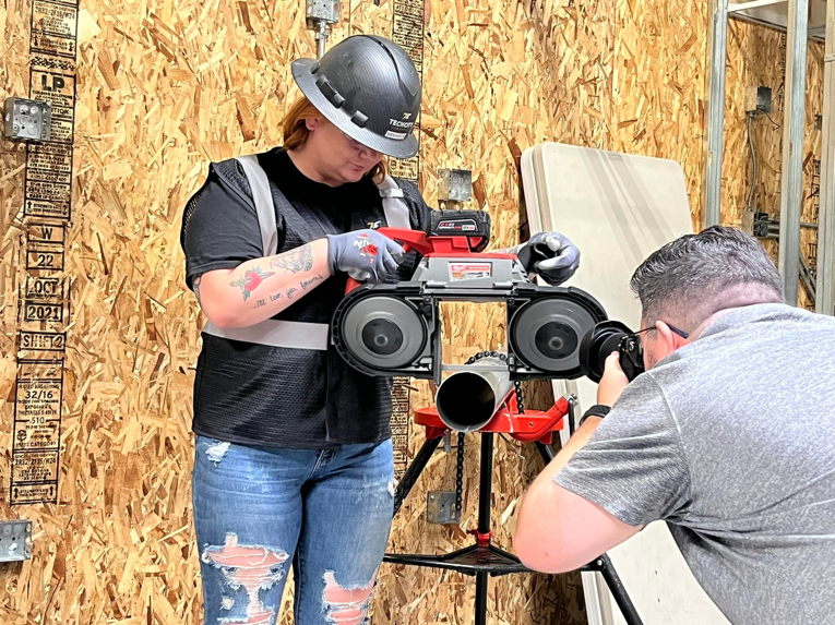 An electrician cutting conduit with a band saw on a job site for TechCity Electric in Fernley, NV