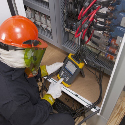 An electrician diagnosing an electrical system with specialized tools for Bay Electric Co. in Newport News, VA.
