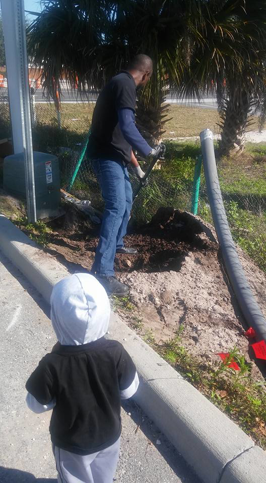 An electrician digging a trench for an electrical installation by Electrical Partners of Central Florida in Altamonte Springs, FL