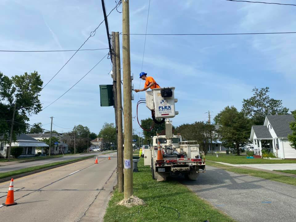 An electrician from FLEX Electric in a bucket truck performing work on a utility pole in Virginia Beach, VA.