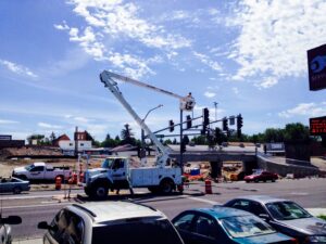 An electrician in a bucket truck repairing traffic lights at an intersection for Wheeler Electric, Inc. in Idaho Falls, ID.