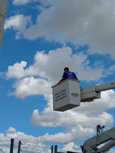 An electrician from Jesse's Electric in uniform, working from a bucket truck in Laredo, TX.