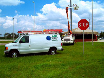 An electrician from Ace Electrical Services in a bucket truck working on an outdoor light pole in Jacksonville, FL.