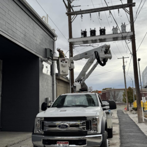 An electrician in a bucket truck working on power lines and transformers for Wheeler Electric, Inc. in Idaho Falls, ID.