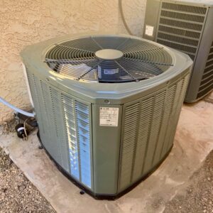 An electrician inspecting an AC unit's electrical panel with a screwdriver for Cool Aid Air Conditioning in Scottsdale, AZ