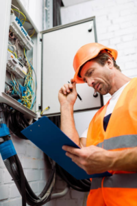An electrician inspecting a residential or commercial breaker panel for Four Corners Electric Co., Inc. in Farmington, NM