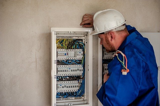 An electrician in a hard hat inspecting an open electrical panel for Right Electrical Services LLC in Raleigh, NC.