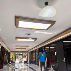 An electrician from Mechatronics LLC inspecting newly installed ceiling lighting in a commercial hallway in Memphis, TN.