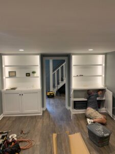 An electrician from Coffin Electric installing built-in shelving with integrated lighting in Grimes, IA.