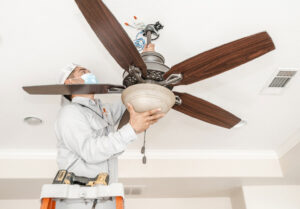 An electrician from 4G Electrician installing a ceiling fan in a residential property in Dallas, TX