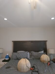 An electrician from LeoElectricservice installing a ceiling fan and recessed lighting in Frisco, TX.