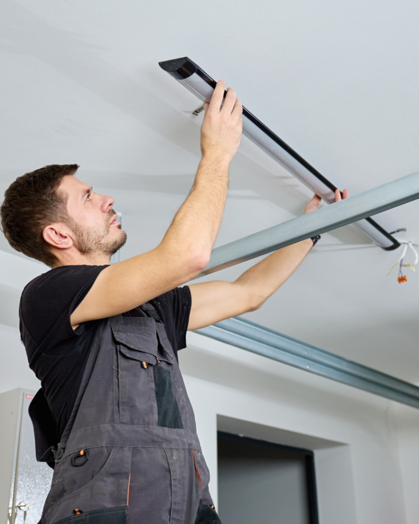 An electrician installing a new ceiling light fixture for Caddo Electrical Contracting, LLC in Shreveport, LA.