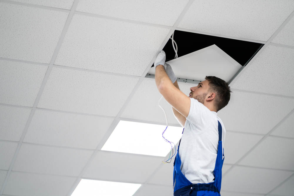 An electrician installing or repairing wiring in a ceiling grid for Polk Electric, LLC in Rock Hill, SC