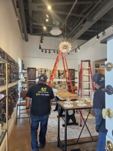 An electrician from Acevedo's Electric installing commercial lighting fixtures in a retail space in Dallas, TX.