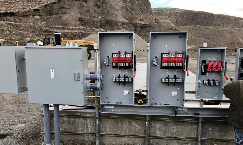 An electrician from Valley Electric Inc in Lewiston, ID, installing commercial lighting and conduits in a large building.