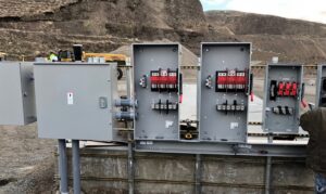 An electrician from Valley Electric Inc in Lewiston, ID, installing commercial lighting and conduits in a large building.