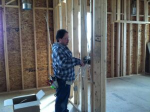 An electrician installing a complex, multi-piece chandelier for President, Cannizzo Electric, Inc. in Rochester, NY.