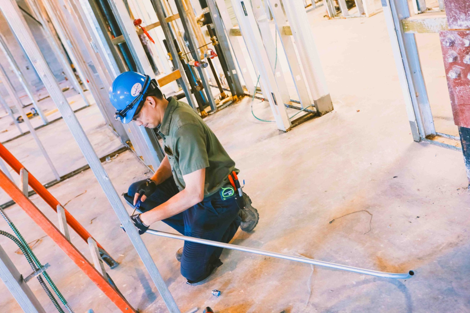 An electrician installing electrical conduit in a new construction project for Bay Electric Co. in Newport News, VA.