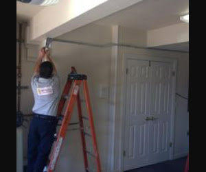 An electrician from BR Electric on a ladder installing electrical conduit on a ceiling in Newcastle, OK.