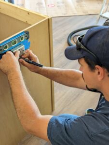 An electrician installing an electrical box using a level for Bright Electric in Evansville, IN.
