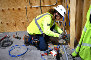 An electrician installing electrical components and wiring on the floor at MetroPower, Inc. in Albany, GA.