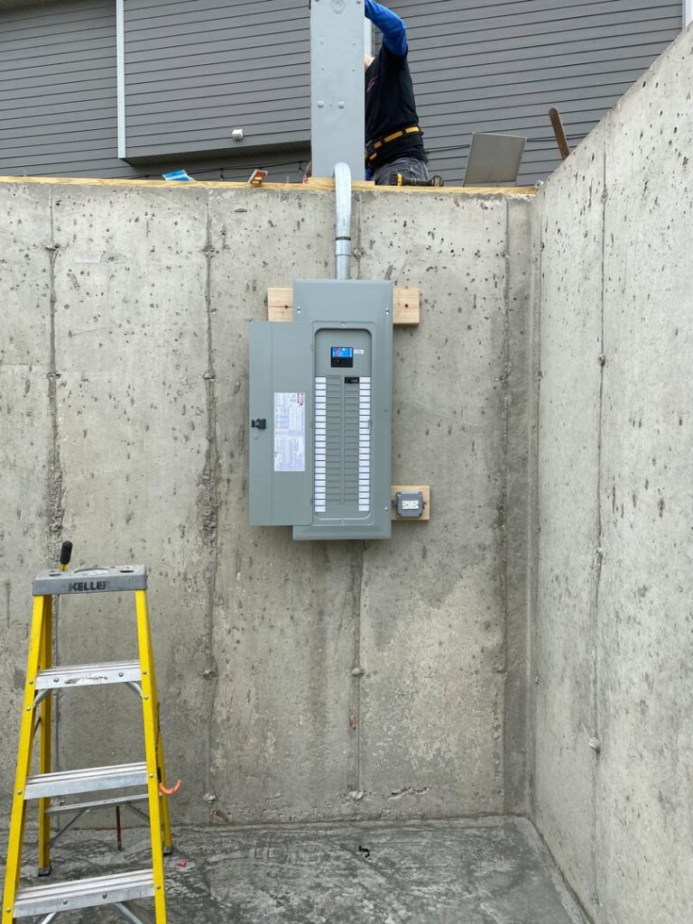 An electrician from Neighborhood Electric installing an electrical meter base at a construction site in West Chicago, IL.
