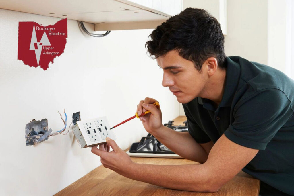 An electrician installing an electrical outlet on a wall, providing service for Buckeye Electric of Upper Arlington, LLC in Columbus, OH.