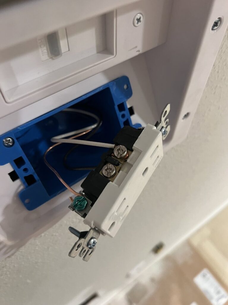 An electrician from Sparrow Electric, LLC installing a new electrical outlet in Denver, CO.