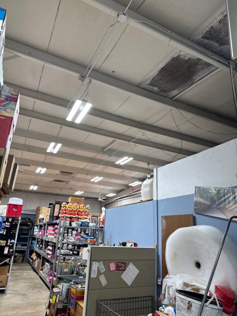 An electrician from Neighborhood Electric installing an electrical panel on a concrete wall in West Chicago, IL.
