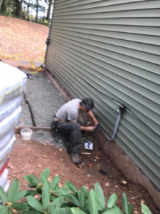 An electrician from 3C Electric Systems installing exterior conduit and wiring on a building in Hartford, CT.