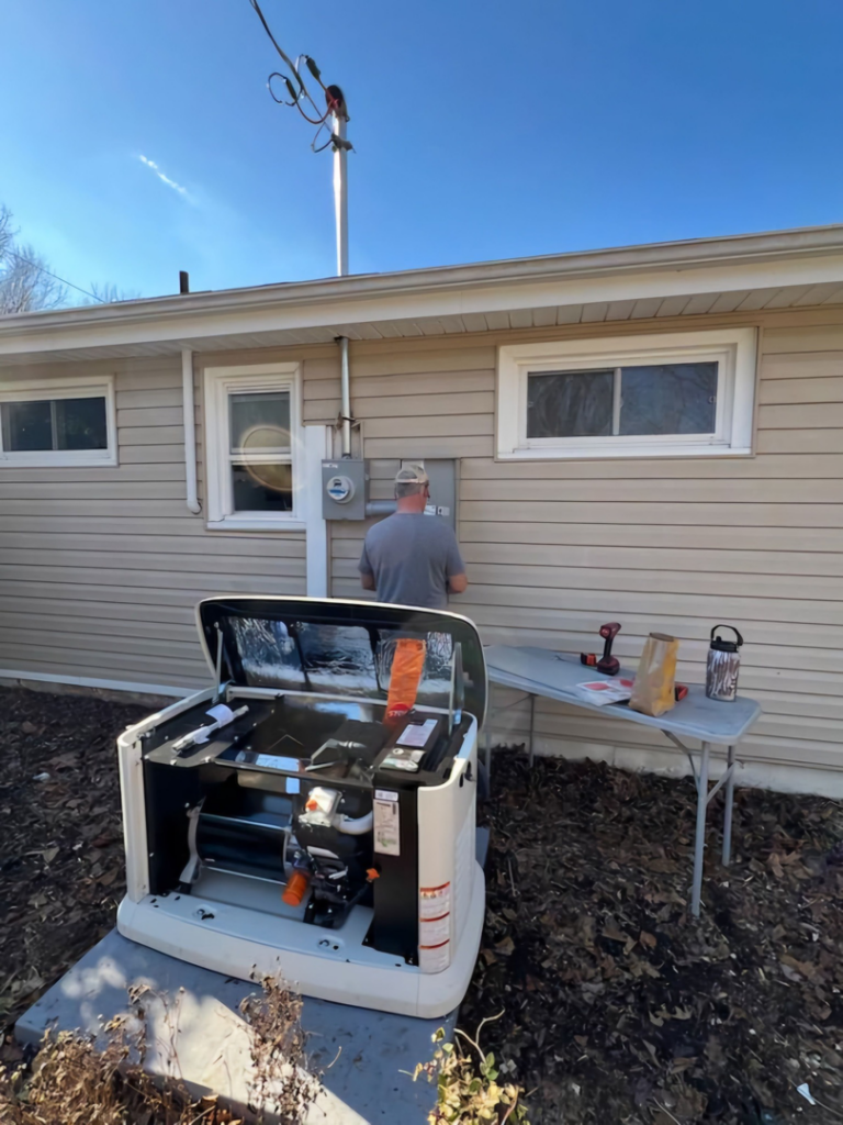 An electrician from RJ Boyd Electric installing a Generac whole-house generator and transfer switch in Christiansburg, VA.