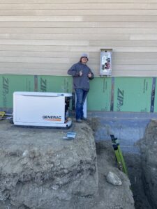 An electrician from Master Controls installing a Generac generator and electrical panel on a construction site in Cheyenne, WY