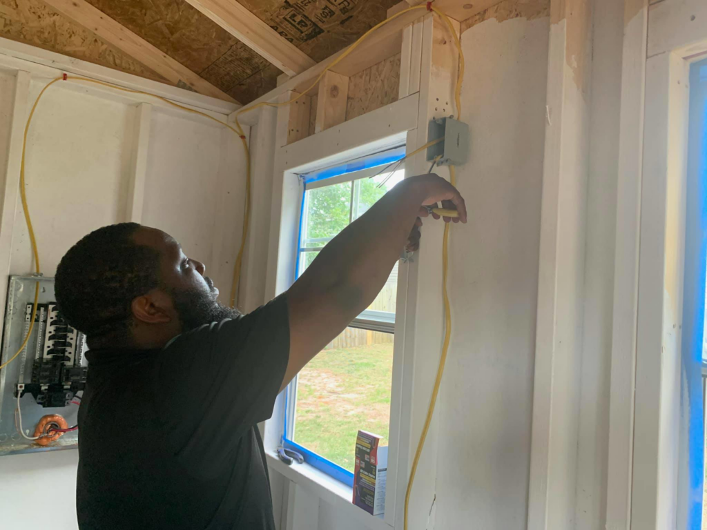 An electrician from Gksquad installing interior wiring and working on an electrical panel in Columbia, SC.