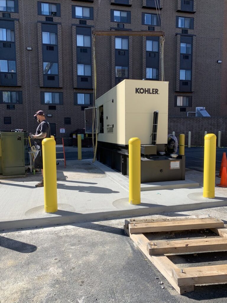 An electrician from Diamond Electric installing a large Kohler commercial generator outside a building in Toledo, OH.