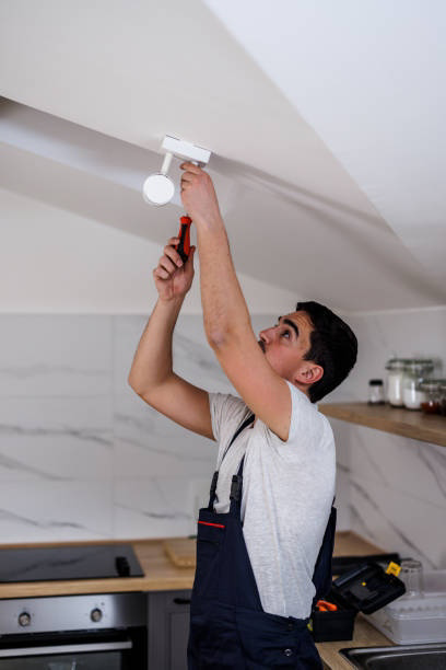 An electrician installing a new light fixture for Crawford Electric Co. LLC in West Columbia, SC.