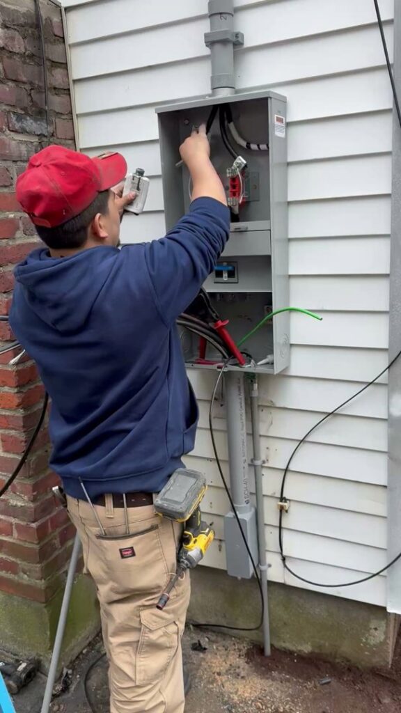 An electrician installing an outdoor electrical panel for Ramos Electrical services inc in Brownsville, TX