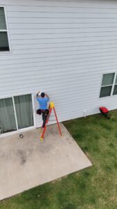 An electrician from Dr. Sparky installing an outdoor light fixture on a home in Nashville, TN