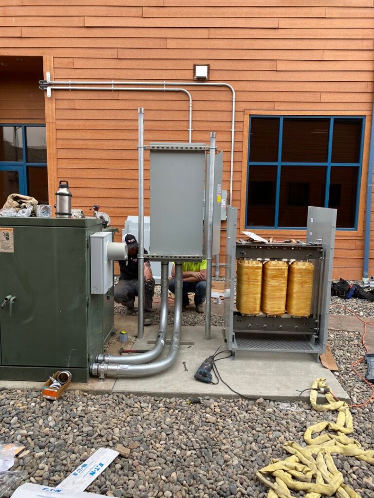 An electrician from Valley Electric Inc in Lewiston, ID, installing an outdoor light fixture from a scissor lift.
