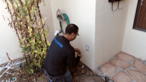An electrician from VG Electric LLC installing an outdoor electrical outlet in Mesilla Park, NM.