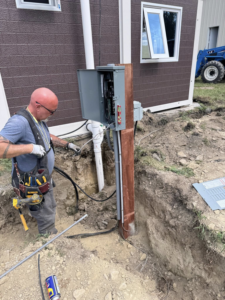 An electrician from Circuit Masters, Inc. installing an outdoor electrical panel in Billings, MT.