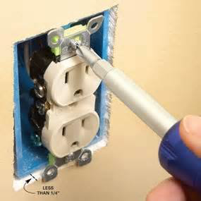 An electrician installing or repairing an electrical outlet with a screwdriver for Dependable Electric in El Paso, TX