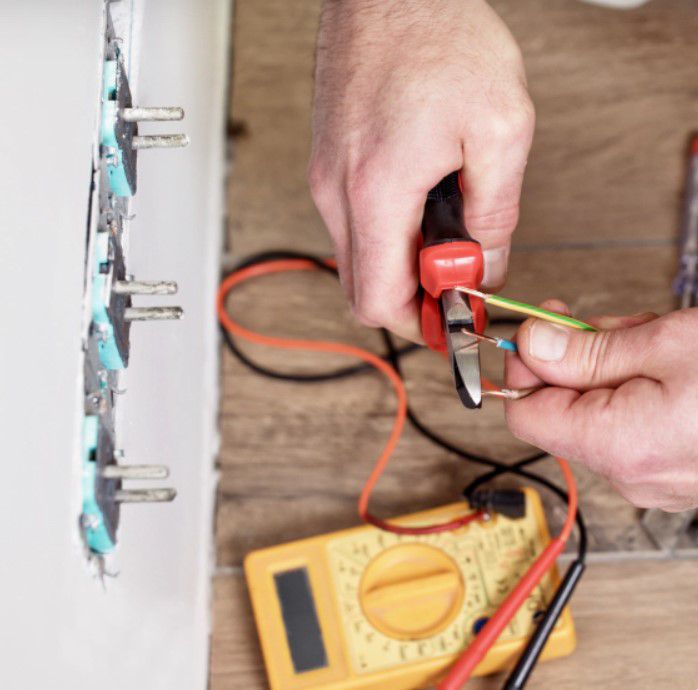An electrician installing an electrical outlet and wiring at Illiana Electrical in Whiting, IN