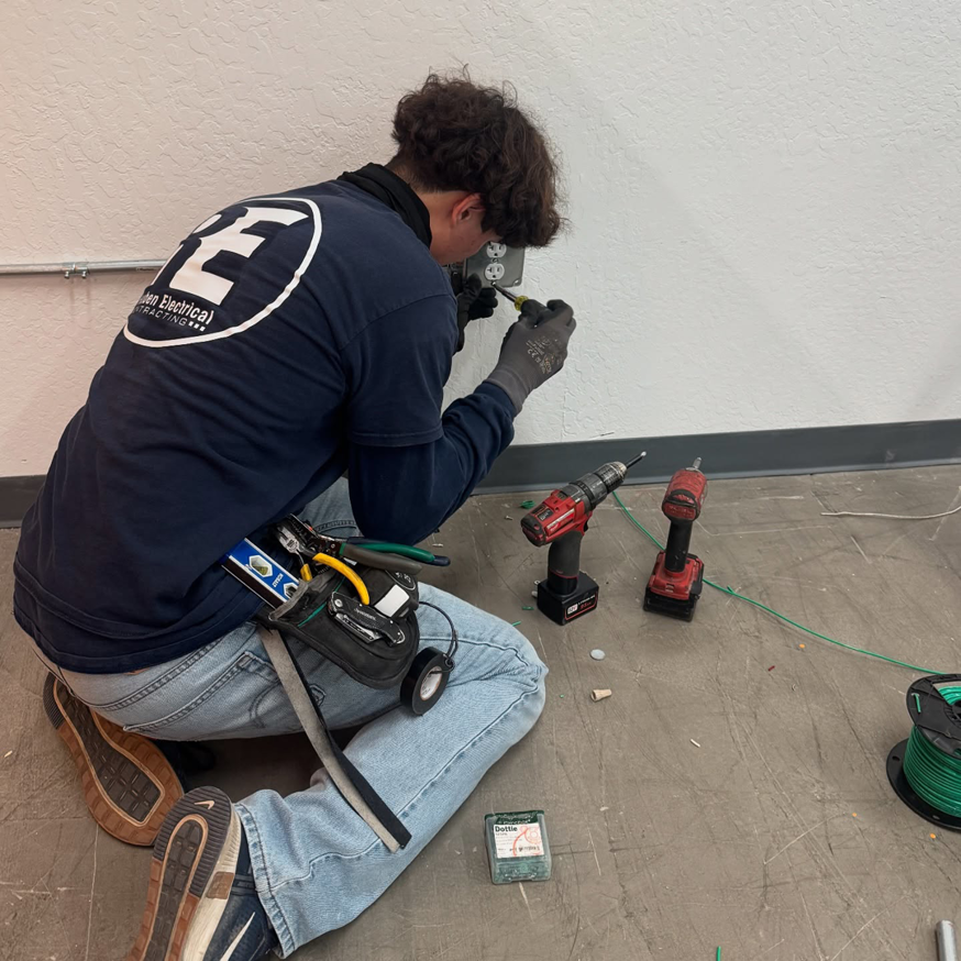 An electrician from Reuben Electrical Contracting installing an electrical outlet in Scottsdale, AZ.