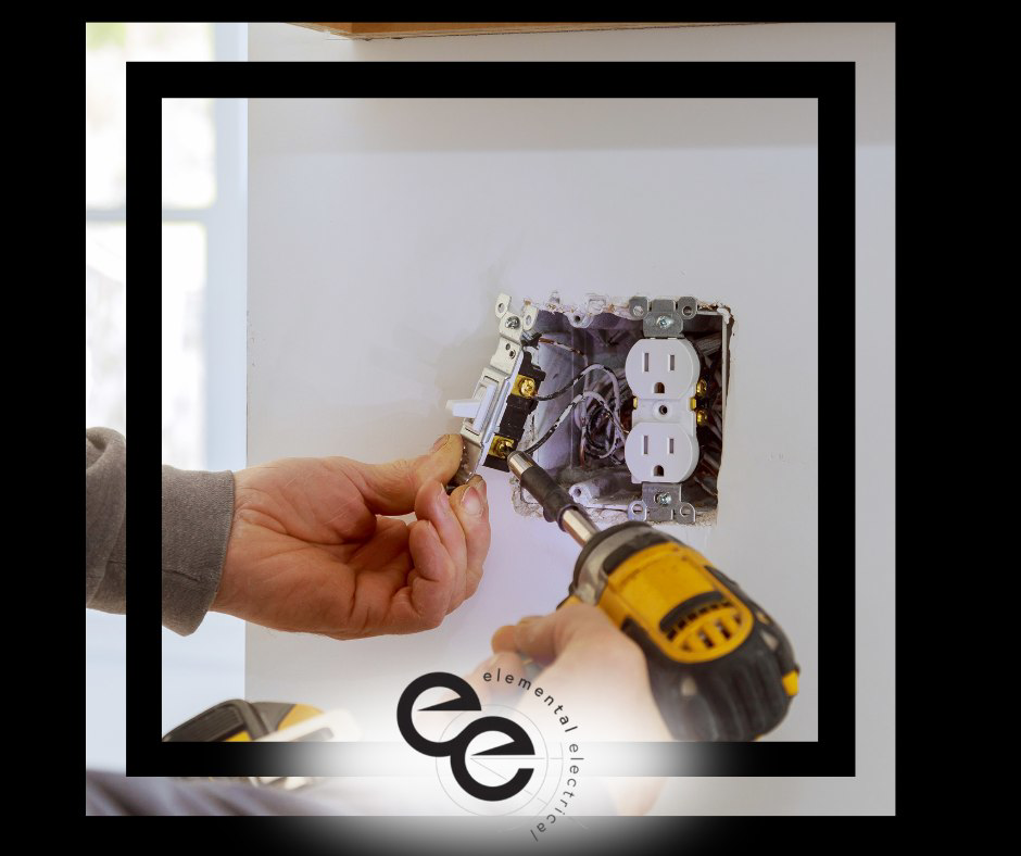 An electrician installing an electrical outlet and light switch with a power drill for Elemental Electrical in Chattanooga, TN.