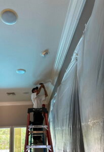 An Electricode electrician on a ladder installing a recessed light fixture in a ceiling in Las Vegas, NV.