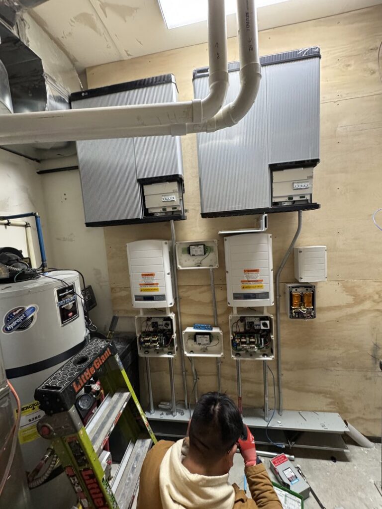 An electrician installing solar inverters and electrical panels for Pioneer Electric LLC in West Valley City, UT.