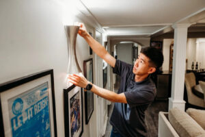An electrician from Arnold Electrical Repair & Installation installing a modern wall sconce in a home in Chicago, IL.
