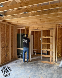An electrician installing new electrical wiring in a home under construction by Brannon Electric, LLC in Canton, GA.