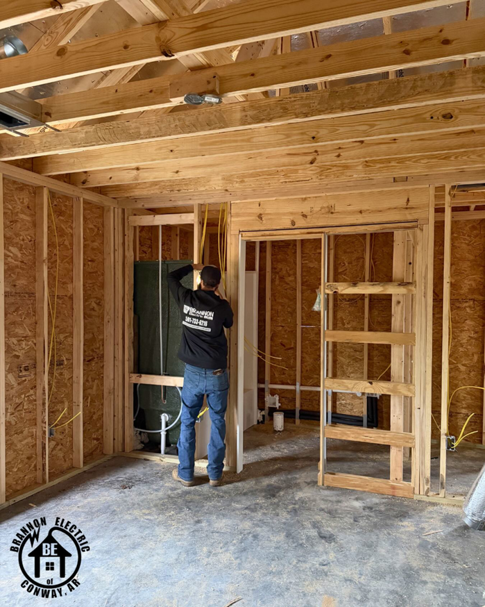 An electrician installing new electrical wiring in a home under construction by Brannon Electric, LLC in Canton, GA.